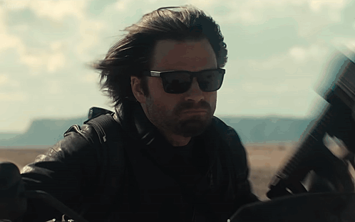 Man in Sunglasses and Leather Jacket Holding Gun