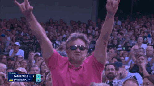 Man in Sunglasses and Pink Shirt Applauding at Tennis