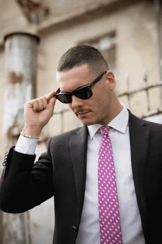 Man in Sunglasses and Pink Tie Adjusting Glasses