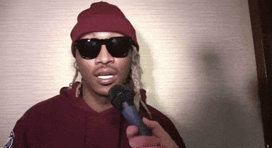 Man in Sunglasses and Red Beanie Holding Microphone