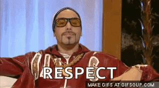 Man in Sunglasses and Red Jacket Sitting Says Respect