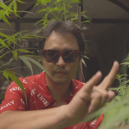 Man in Sunglasses and Red Shirt Giving Middle Finger