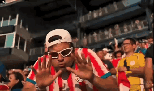 Man in Sunglasses and Red Striped Shirt in Crowd