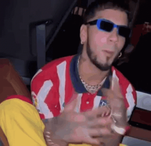 Man in Sunglasses and Red White Striped Shirt Sitting Down