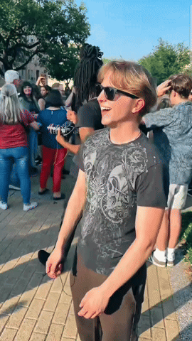 Man In Sunglasses And Skull Shirt In Front Of Crowd GIF