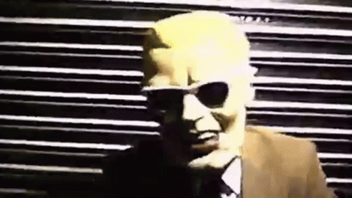 Man in Sunglasses and Suit by Striped Wall