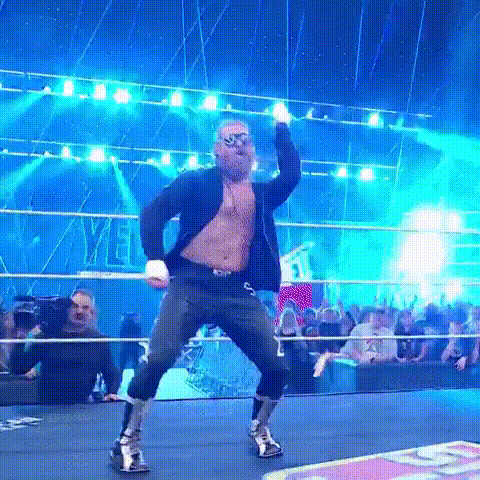 Man in Sunglasses and Suit Dancing in Wrestling Ring