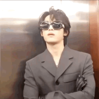 Man in Sunglasses and Suit Standing in Elevator