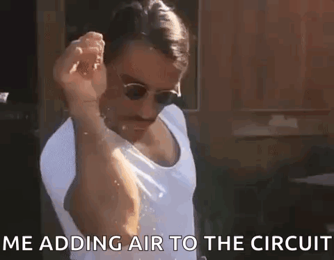 Man in Sunglasses and Tank Top Adding Air to Circuit