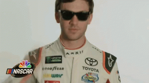 Man in Sunglasses and Toyota Racing Suit in Front of NASCAR Logo