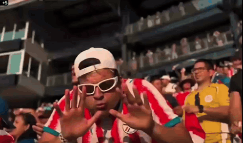 Man in Sunglasses and White Hat in Crowd