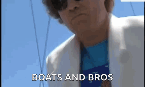 Man in Sunglasses and White Jacket on a Boat