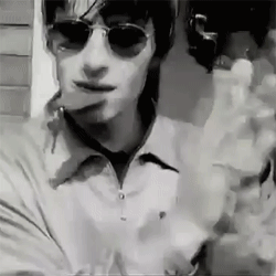 Man in Sunglasses and White Shirt Smoking Cigarette