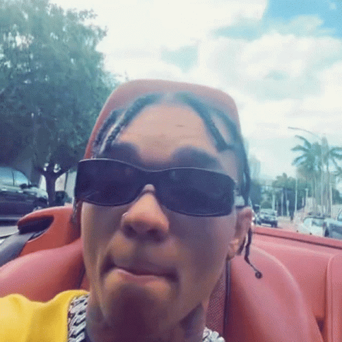 Man in Sunglasses and Yellow Shirt Sitting in Car