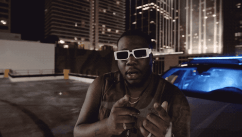 Man in Sunglasses by Blue Car