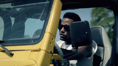 Man in Sunglasses Driving Yellow Vehicle