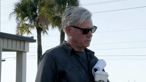 Man in Sunglasses Holding Coffee