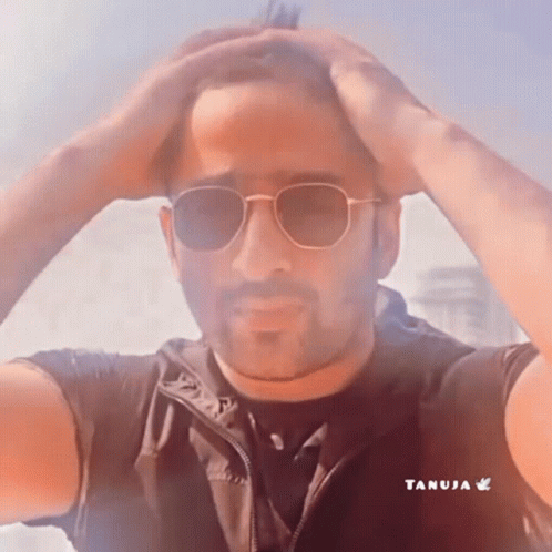 Man in Sunglasses Holding Hand to Forehead