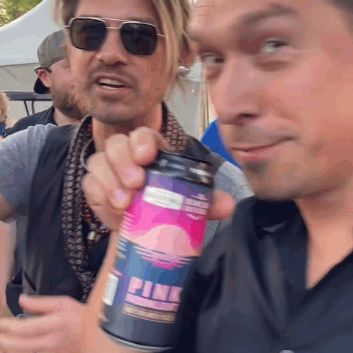 Man in Sunglasses Holding Pink Can