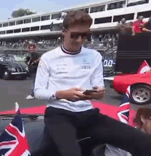Man in Sunglasses on Car Looking at Phone