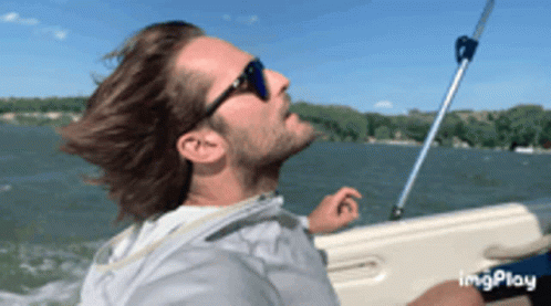 Man In Sunglasses Riding Boat On Lake GIF