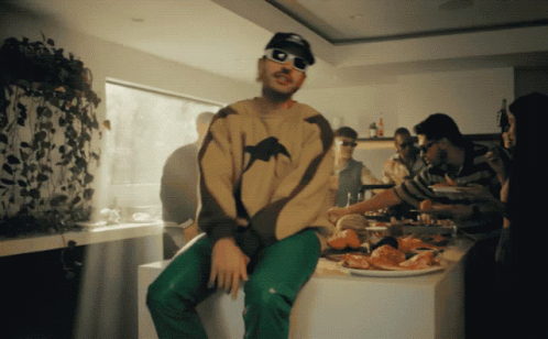 Man in Sunglasses Sitting on Counter with Food