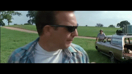 Man in Sunglasses Standing by Car in Field
