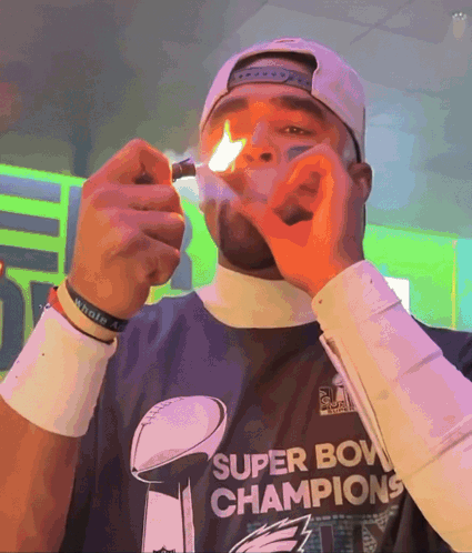 Man in Super Bowl Champions Shirt Lighting Cigarette