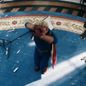 Man in Superhero Costume Kneeling on Blue Rug