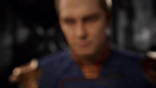 Man in Superhero Costume Looking at Bottle