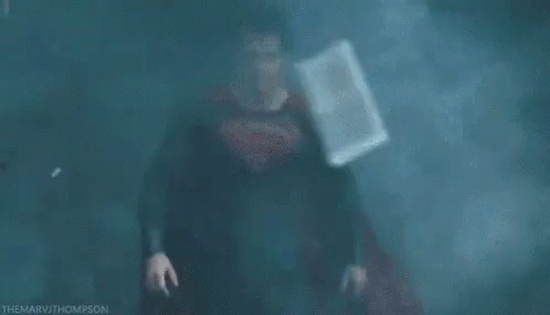 Man in Superman Costume in Dark Foggy Room
