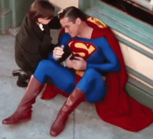 Man in Superman Costume Sitting on Ground
