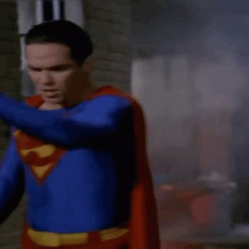Man in Superman Costume Standing in Front of Brick Wall