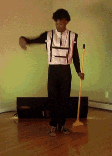 Man in Suspenders Holding Broom and Dancing