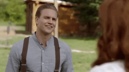 Man in Suspenders Talking to Woman in Park