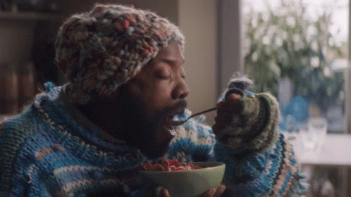 Man In Sweater And Hat Eating Cereal GIF