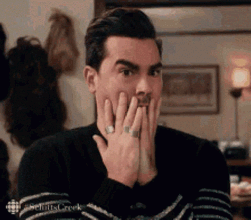 Man In Sweater Covering Mouth GIF