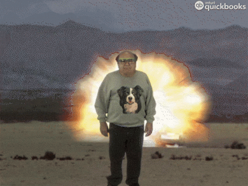 Man in Sweater with Dog Standing in Front of Explosion