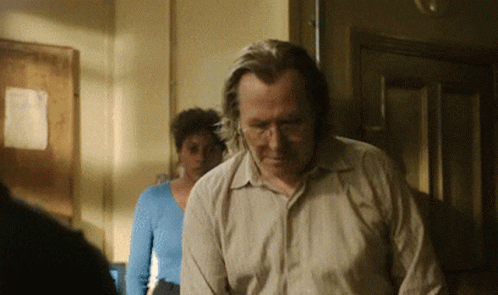 Man in Tan Shirt Standing in Front of Woman in Blue Top
