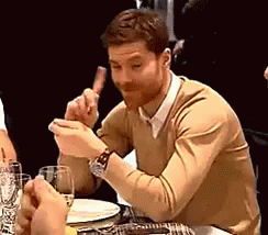 Man in Tan Sweater Eating Meat