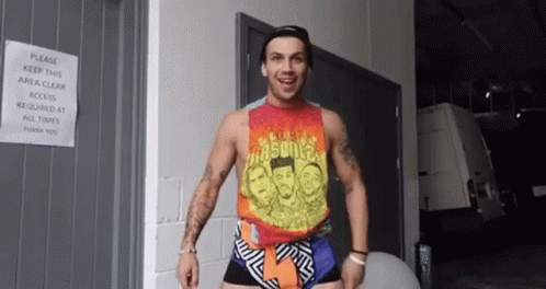 Man in Tank Top and Shorts Standing in Front of Door