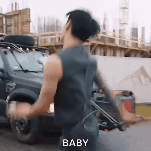 Man in Tank Top Dancing Next to Car