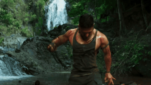 Man In Tank Top In Front Of Waterfall GIF
