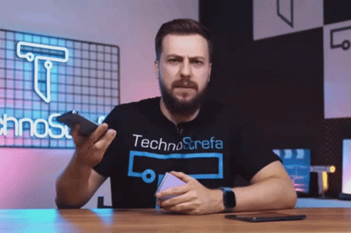 Man in Technostrefa T-Shirt Holding Phone