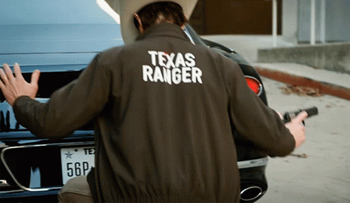 Man In Texas Ranger Jacket Holding Gun GIF