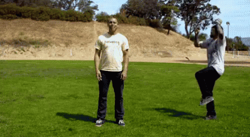 Man In Thrasher Shirt Jumping In Field GIF