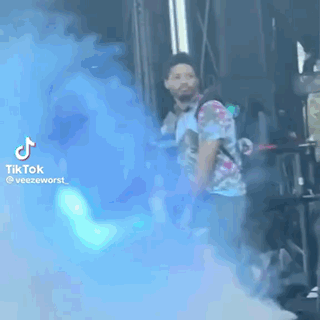 Man in Tie Dye Shirt With Blue Smoke Bomb