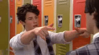 Man in Tie Pointing at Another Man by Lockers
