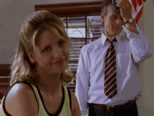 Man in Tie Wipes Forehead Woman Watches