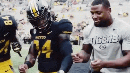 Man in Tigers Shirt Next to Mizzou Football Player